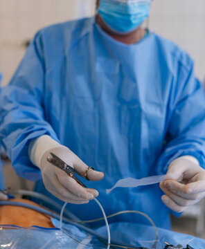 Surgeon cutting surgical mesh for hernia repair surgery