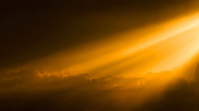 A dawn landscape with powerful golden rays of the sun breaking through dark storm clouds and fog over a field and tree silhouettes.