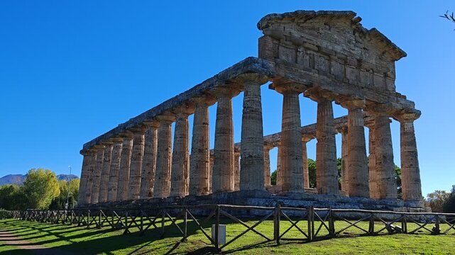 Ancient Greek Temple of Athena in Paestum, Italy at sunny day with blue sky. Famous archaeological site of Paestum, Magna Graecia, ancient ruins.