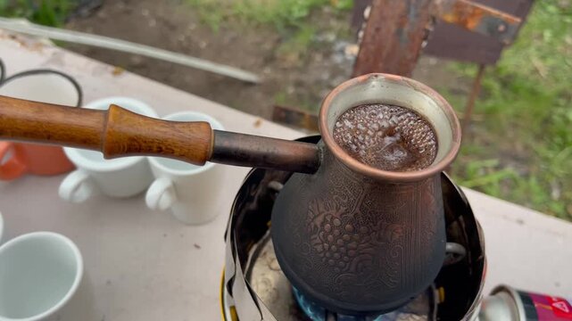 Brewing traditional Turkish coffee in a copper cezve on a camping stove.