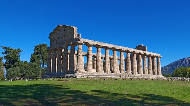 Ancient Greek Temple of Athena in Paestum, Italy at sunny day with blue sky. Famous archaeological site of Paestum, Magna Graecia, ancient ruins.