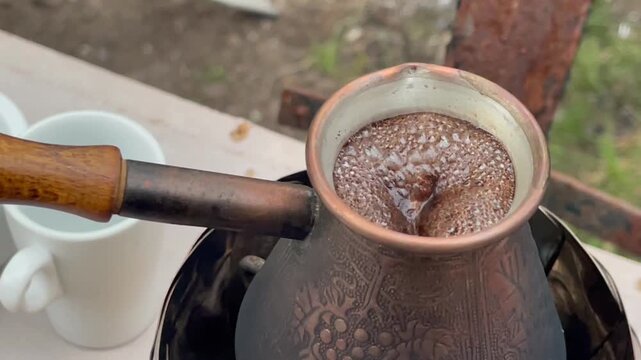 Brewing traditional Turkish coffee in a copper cezve on a camping stove.
