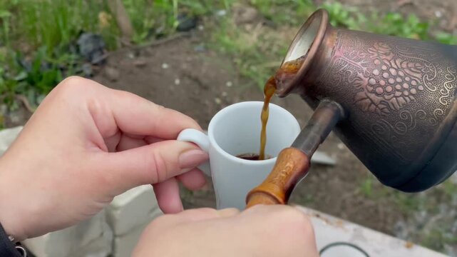 Brewing traditional Turkish coffee in a copper cezve on a camping stove.