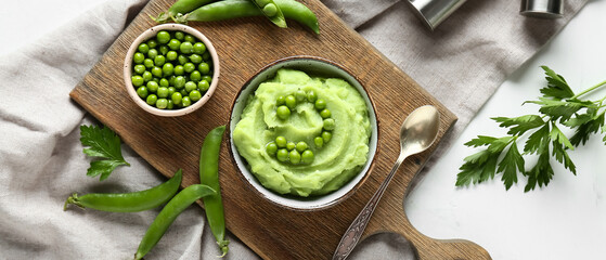 Fototapeta premium Bowl with mashed green peas and parsley on white background