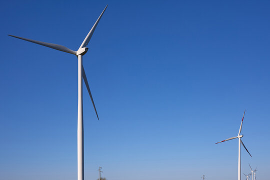 Wind turbines at sunset in green field &ndash; renewable energy, clean power, sustainable future.