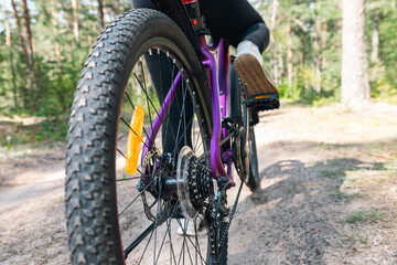 Naklejka premium Close-up of a bicycle parked on a dirt trail, with a focus on the kickstand. The bike's rugged tires are well-suited for trail riding, and the scene suggests a forest environment.