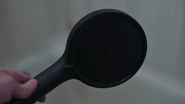Demonstration of a versatile shower head with interchangeable features.
