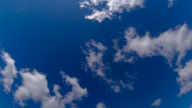 Beautiful timelapse of white clouds moving quickly across a bright blue sky on a sunny day