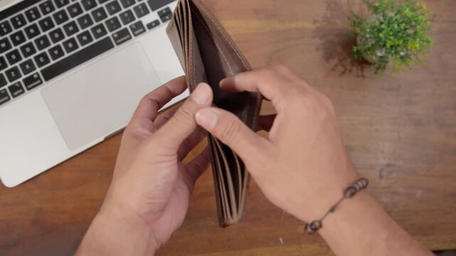 Close-up of hands showing an empty wallet, symbolizing financial problems, lack of money, economic pressure, and budgeting difficulties.