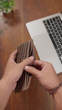 A person holding an empty wallet with no money inside, illustrating financial hardship, economic struggle, debt, and personal finance challenges in everyday life.