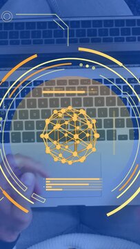 Vertical video: Man lowering phone, typing on laptop keys, yellow HUD sphere rotating while coding