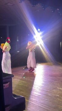 Authentic flamenco performance by two female dancers with fans under dramatic stage lighting