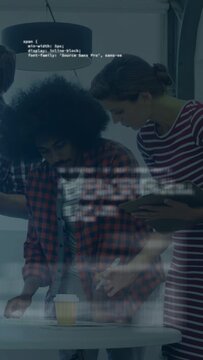 Vertical video: Team checking device on round table, code appearing on glass, aiding tech review
