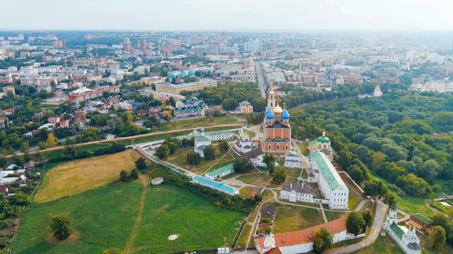 Ryazan, Russia. Ryazan Kremlin, Drone footage over the Assumption Cathedral with its blue and golden domes rising above the historic fortified complex at the modern city skyline under soft summer lig