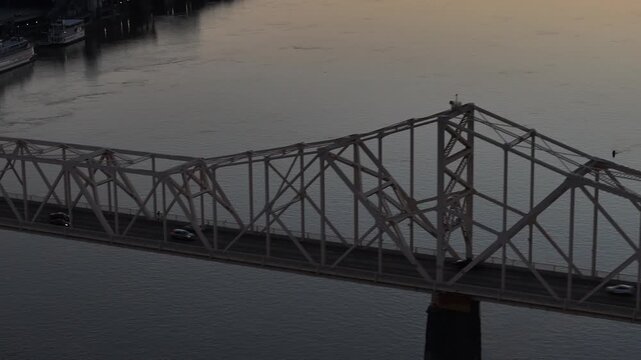 Aerial view of the George Rogers Clark Memorial Bridge spanning the Ohio River with calm water and distant boats during twilight Louisville, Kentucky, United States.
