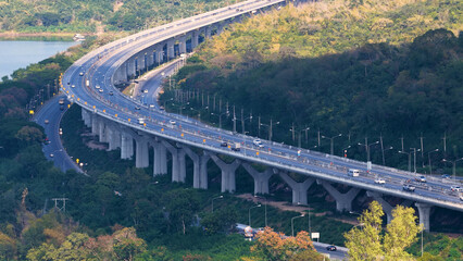 Obraz premium Aerial View of Curved Elevated Motorway Passing Through Lush Green Hills