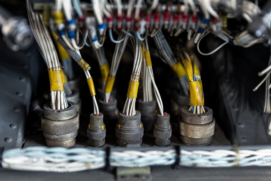 Aircraft wiring and avionics connectors inside maintenance compartment bundled cables industrial electronics. Technical aviation infrastructure show engineering systems repair service control network
