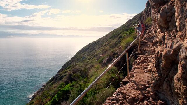 Hikers on steep hiking trail next to coastal cliff at Robberg Nature Reserve