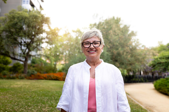 Senior woman smiling in park enjoying retirement lifestyle