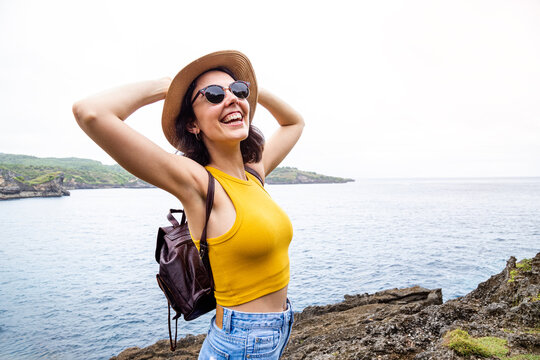 Happy woman traveling enjoying freedom on ocean coast