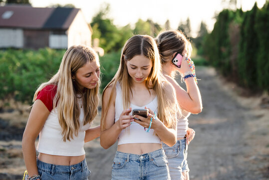 Girls looking at phones outside in the summer