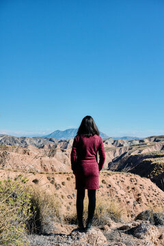 Female traveler admiring a vast badlands desert landscape