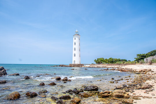 Lighthouse Standing Over Crystal Blue Waters and Rocky Coast in Sri Lanka