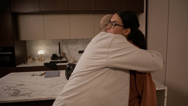 Medium shot of adult man hugging ex spouse and taking suitcase, leaving flat after divorce