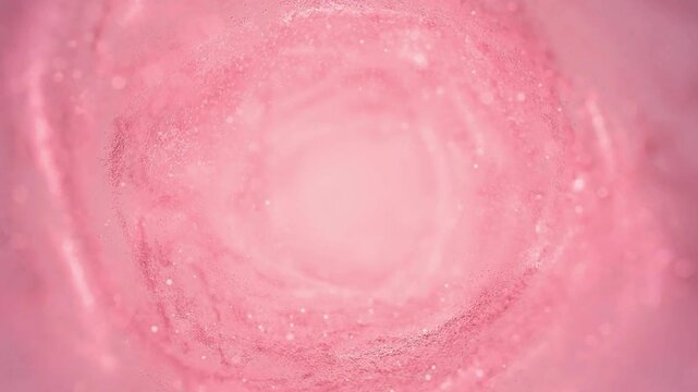 Soft pink swirling tunnel of cosmic dust and light particles creating abstract tunnel effect, cinematic motion background.