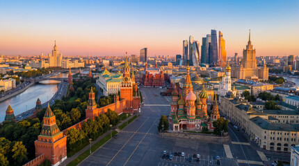 Obraz premium Panoramic view of Moscow's Red Square and Kremlin at sunrise with modern skyscrapers in the background.