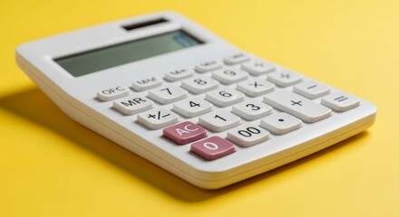 Obraz premium Close-up of a sleek white calculator with prominent buttons and a digital screen, isolated on a vibrant yellow background, showcasing its modern design and functionality for financial tasks.
