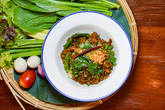 Spicy Minced Fish Salad with Fresh Herbs, Traditional Larb Pla Khua Served in White Bowl, Authentic Thai Roasted Fish with Chili and Mint
