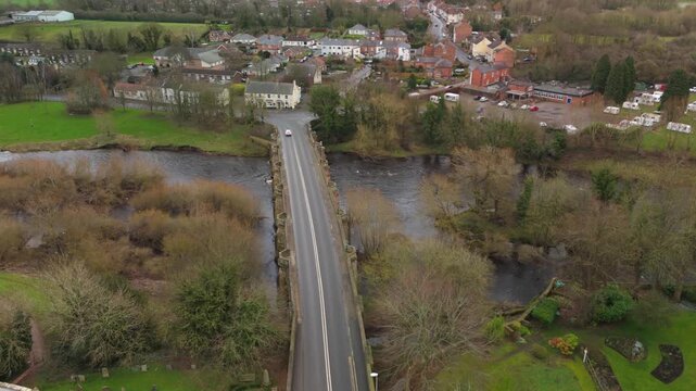 Croft-on-Tees UK: 21st Feb 2026: Drone view captures Croft-on-Tees. The scene shows houses, a river, fields, and bridge. Green trees and open spaces surround the area
