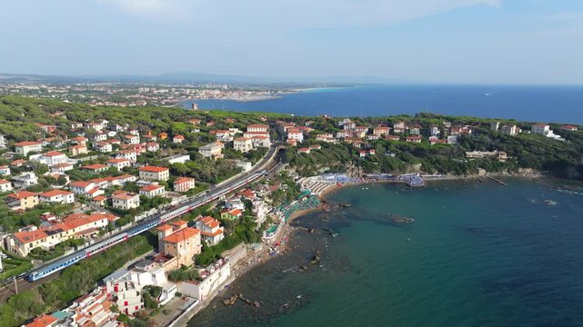 magical aerial view, upscale shoreline of Castiglioncello, Italy, high-speed train moves northward through the storied coastal enclave