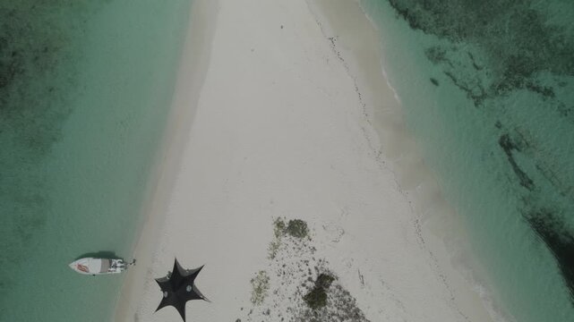 Aerial top down to tilt up reveal of an expansive sandbar beach connecting remote islands in Los Roques Archipelago National Park Venezuela, vast turquoise Caribbean waters stretching to the horizon