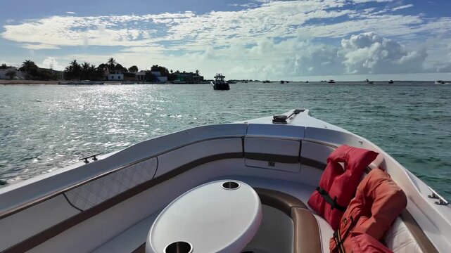 POV inside luxury speedboat with life jackets near Gran Roque shore, fast sailing in clear Caribbean waters, spray, sunny day, Los Roques island travel