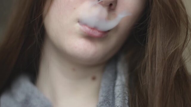 Portrait of young woman intending to quit smoking uses electronic cigarette