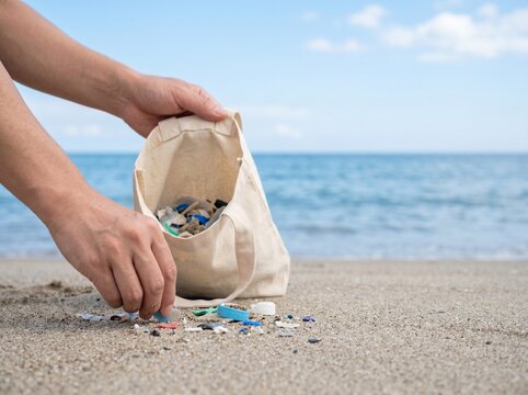 Hands Collecting Plastic Waste on Beach for Umi no Hi Marine Day Ocean Cleanup Photo with Copy Space