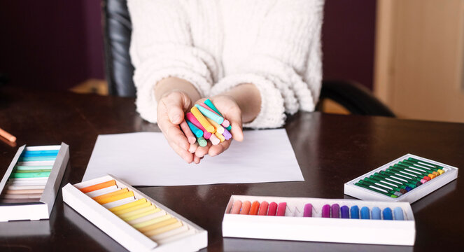 Woman writing with colored pencils on a piece of paper