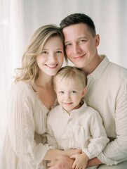Fototapeta premium Happy Family Portrait with Parents and Toddler in Soft Natural Light