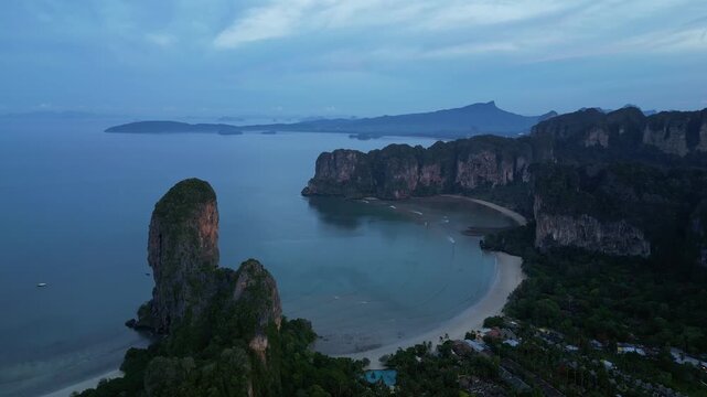 Krabi, Thailand : Aerial drone footage of the famous Railay beach and various beachfront resort surrounded by dramatic karst in coastline of Krabi, Thailand on sunrise. Taken with orbit motion
