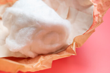 Naklejka premium Cotton wool on pink background with space for text. Medical or cosmetic natural cotton wool. Eco-friendly fiber material for personal hygiene
