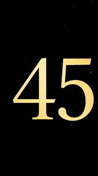 Gold Glitter Blow‑Away Reveal of Number 45 on Solid Background