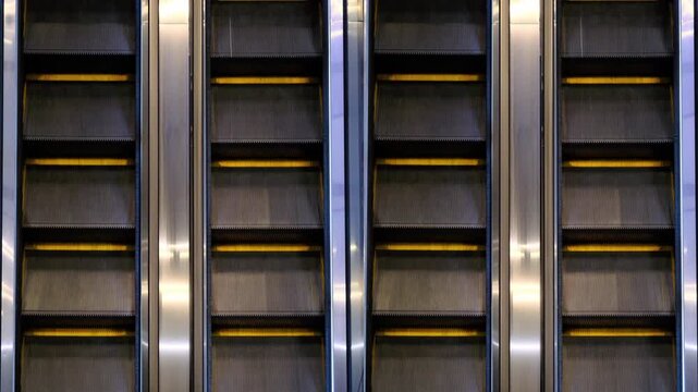 the steps of an empty escalator move up close up view from above
