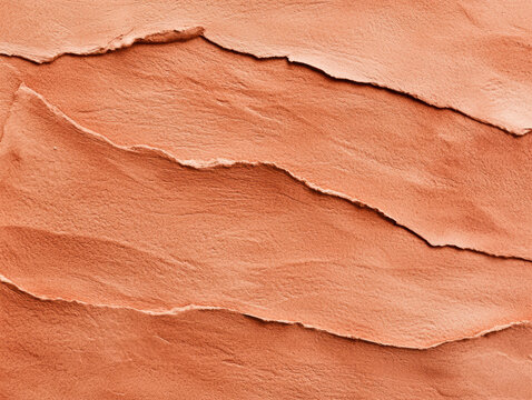 Layers of reddish-orange textured sandstone with natural, wavy strata lines creating a scenic and rugged geological pattern.