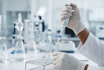 Fototapeta premium Scientist hands using mechanical pipette over lab test tubes