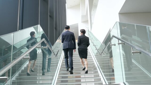 階段を登る男女ビジネスパーソンのグループ