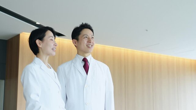 画面を見ながら会話する白衣の男女グループ