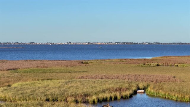 Static daytime view of Ilha da Polvora marshland on Lagoa dos Patos with S&atilde;o Jos&eacute; do Norte city in the distance.