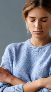 A contemplative moment captured in soft hues, showcasing a young woman's introspective expression while dressed in a cozy blue sweater, embodying a sense of tranquility and reflection.